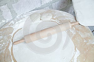 Dough with rolling pin on table