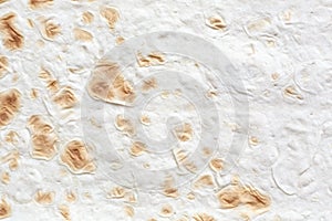 Dough texture of Armenian Lavash bread, natural beige background with golden brown inclusions.