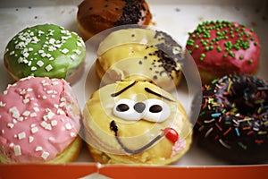 Doughnuts in box whith fruit frosting and smile face