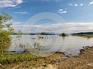 Douglas Lake in the spring in Tennessee with the Great Smoky Mountains in the background, the water and sandy shore with a blue