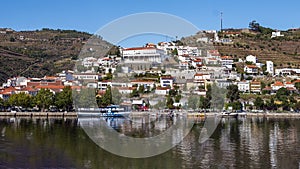 The Douro River, tour boats, hillsides, terraces and buildings of the town of Pinhao, Portugal, on a bright sunny day. photo