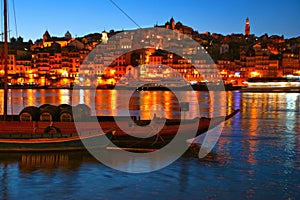 Douro river and traditional boats at night in Oporto