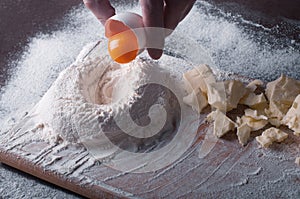 Douth, food, cooking concept - preparing douth - cooking progress and ingridients, Chef pours egg yolk from eggshell into flour