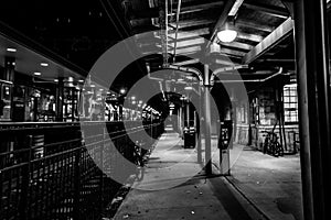 Dover, NJ USA - November 1, 2017: Bicycles rest along the grungy train station at night, black and white