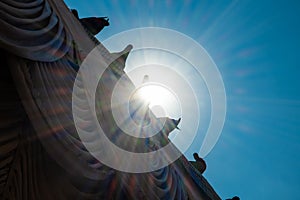 Doves sitting on the roof against the background of blue sky and sunbeams. Rainbow optical effect from the sun.