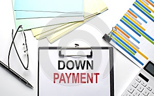 DOWN PAYMENT text on paper sheet with chart,color paper and calculator