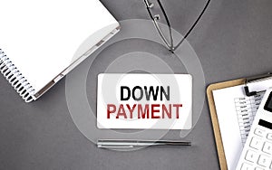 DOWN PAYMENT Text written on the card with notebook and clipboard, grey background