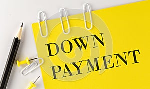 DOWN PAYMENT word on the yellow paper with office tools on the white background