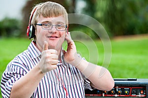 Down syndrome boy with headset doing thumbs up.