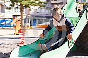 Down syndrome kid playing on slide at park