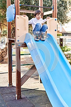 Down syndrome kid playing on slide at park