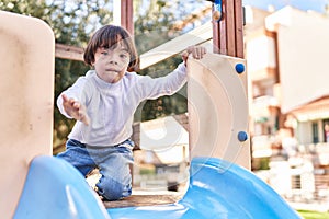 Down syndrome kid playing on slide at park