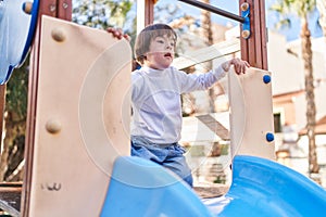 Down syndrome kid playing on slide at park