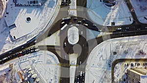 Down view of intersection in winter, circle crossroad with traffic and snow