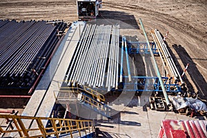 Down view through Rig floor stairs to pipes on pipe rack next to catwalk