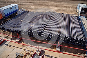 Down view through Rig floor stairs to pipes on pipe rack next to catwalk. Looking up derrick at pipes in a rack on an offshore oil