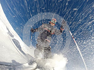 Downhill alpine skiing at high speed on powder snow.