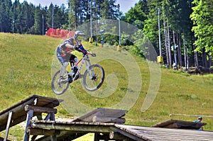 Downhill bike rider jumping off ground at mountain bike race