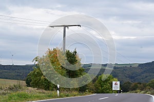 downhill road with a slow down warning for the dangerous curves agead