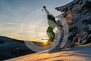 Downhill skier hitting a tree while jumping in powder snow and sunset conditions