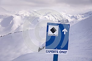 Downhill skiers on Whistler Mountain, expert only ski run sign, ski mountain, winter, ski hill.