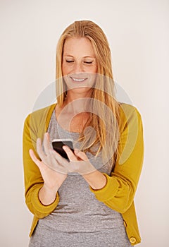 Downloading a new app is so easy. a happy woman sending a text message on her mobile phone.