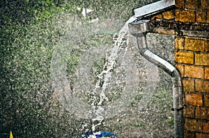 Downpipe is discharging water over a downpipe shoe straight into a flooded street rain