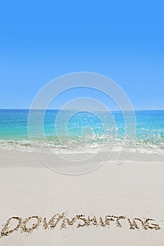 Downshifting text on sandy beach