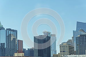 Downtown austin texas with office building and reflective glass with blue and hazy white sky in afternoon sun midday