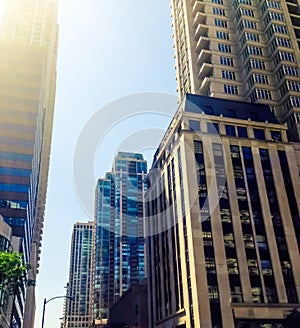 Downtown Chicago buildings looking upward showing several prominent buildings under a blue sky.