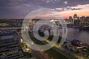 Downtown district of Cincinnati city in Ohio, USA at night with driving cars traffic on bridge and brightly illuminated