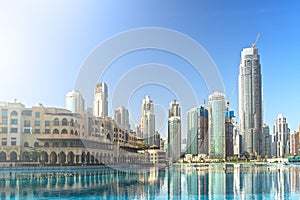 Downtown Dubai skyline in morning with high rise buildings reflected in pool water. United Arab Emirates, UAE