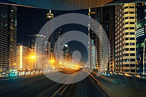 Downtown Dubai skyline by night seen from metro train