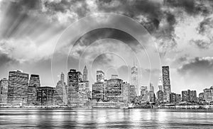 Downtown Manhattan at night from Brooklyn Bridge Park. New York City skyscrapers reflections in the river