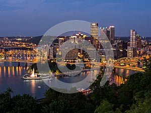 Downtown Pittsburgh skyline at night with rivers, bridges, and the fountain at Point State Park