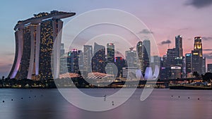 Downtown skyline of Singapore as viewed from across the water from The Garden East day to night timelapse. Singapore.