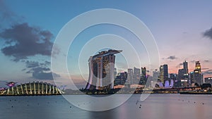 Downtown skyline of Singapore as viewed from across the water from The Garden East day to night timelapse. Singapore.