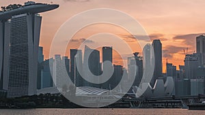 Downtown skyline of Singapore as viewed from across the water from The Garden East day to night timelapse. Singapore.