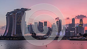 Downtown skyline of Singapore as viewed from across the water from The Garden East day to night timelapse. Singapore.