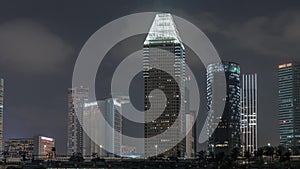 Downtown skyline of Singapore as viewed from across the water from The Garden East night timelapse. Singapore.