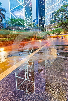 Downtown skyscrapers with road reflections at night, Hong Kong.