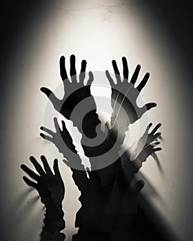 A downturned parent and child clasping hands surrounded by jagged shadows that reach up to their faces. Psychology