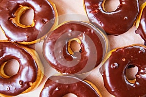 Downward above shot of chocolate glazed donuts with no hole on white tray background