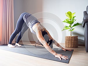 Downward facing dog yoga pose asian woman home workout fitness body weight exercise pilates health training sport healthy