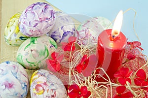 Dozen of handcolored Easter eggs and a burning candle photo