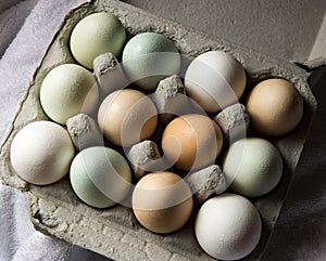 Dozen of multicolored fresh farm eggs in container