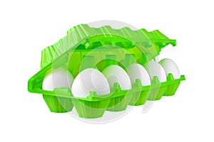 Dozen white eggs in bright green plastic package on white background isolated closeup side view