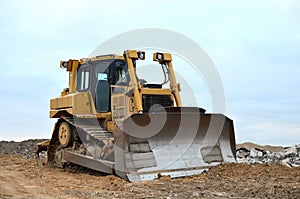 Dozer with bucket for pool excavation and utility trenching. Bulldozer during land clearing and foundation digging at construction