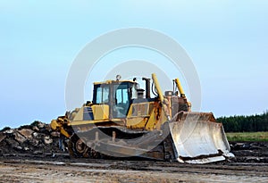 Dozer with bucket for pool excavation and utility trenching. Bulldozer during land clearing and foundation digging at construction