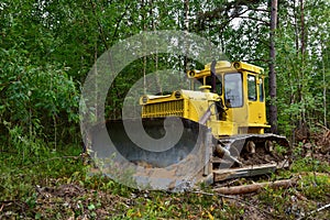 Dozer during clearing forest for construction new road . Yellow Bulldozer at forestry work Earth-moving equipment at road work,